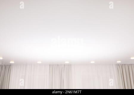 Weiße Stretch-Decke mit Spots im Zimmer, Blick aus niedrigem Winkel Stockfoto