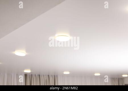Weiße Stretchdecke mit Spots im Zimmer Stockfoto