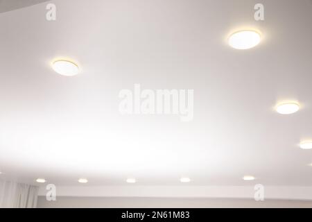 Weiße Stretch-Decke mit Spots im Zimmer, Blick aus niedrigem Winkel Stockfoto