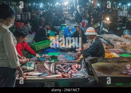 Kambodschaner schneiden und reinigen Fisch auf dem Hauptmarkt für Gemüse und Fleisch bei Nacht. Phsar Dumkor, Phnom Penh, Kambodscha. © Kraig Stockfoto