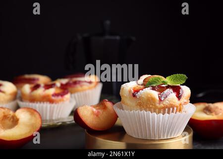 Leckere Cupcakes mit Pflaumen auf schwarzem Tisch, Nahaufnahme Stockfoto