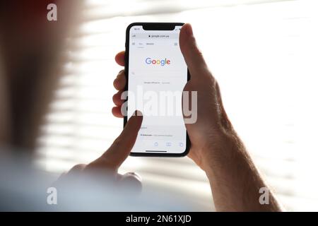 MYKOLAIV, UKRAINE - 27. OKTOBER 2020: Mann, der die Google-Suchmaschine auf einem Smartphone vor unscharfem Hintergrund verwendet, Nahaufnahme Stockfoto