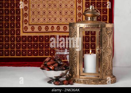 Muslimische Laterne mit Datteln und ein Glas Wasser für Ramadan auf dem Tisch Stockfoto