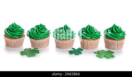 Leckere Cupcakes für St. Patrick's Day und Klee isoliert auf weißem Hintergrund Stockfoto