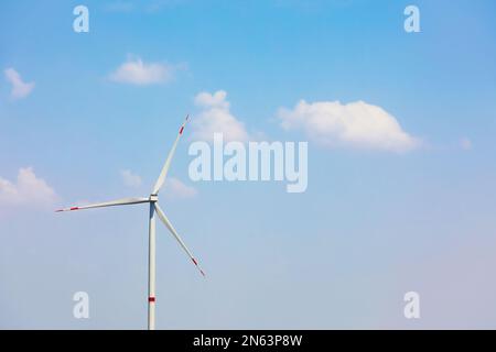 Moderne Windturbine vor blauem Himmel. Energieeffizienz Stockfoto