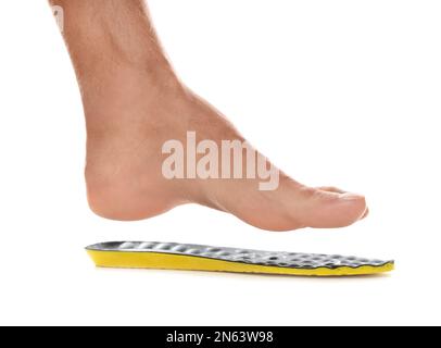 Mann mit orthopädischer Einlegesohle auf weißem Hintergrund, Nahaufnahme. Fußpflege Stockfoto