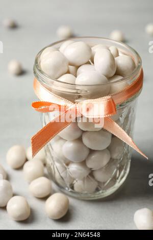 Glasbecher mit Süßigkeiten auf hellgrauem Tisch, Nahaufnahme Stockfoto