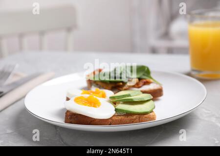 Zum Frühstück werden köstliche Sandwiches auf einem grauen Tisch serviert Stockfoto