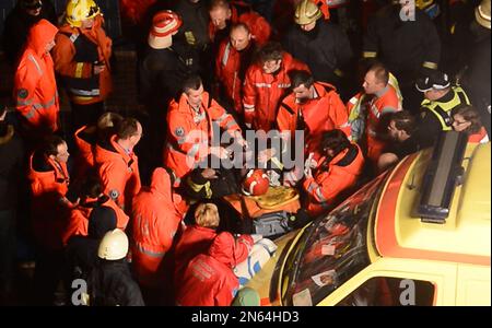 A medical worker uses a defibrillator to treat a victim of a roof collapse the Maxima supermarket in Riga, Latvia, late Thursday, Nov. 21, 2013, as other rescuers gather around. At least 32 people died, including three firefighters, after an enormous section of roof collapsed at a Latvian supermarket in the country's capital, emergency medical officials said Friday. The reason for the collapse during shopping rush-hour Thursday was still not known but rescue and police officials said that possible theories include building's design flaws and poor construction work. (AP Photo/ Maris Morkans)