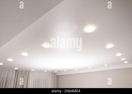 Weiße Stretchdecke mit Spots im Zimmer Stockfoto