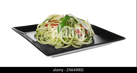 Leckere Zucchini-Pasta mit Tomaten und Basilikum, isoliert auf Weiß Stockfoto