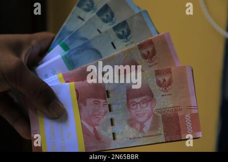 Stapel mit 100.000- und 50.000-IDR-Rupiah-Banknoten auf schwarzem Hintergrund Stockfoto