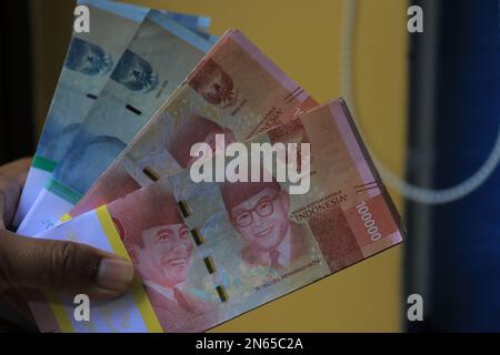 Stapel mit 100.000- und 50.000-IDR-Rupiah-Banknoten auf schwarzem Hintergrund Stockfoto