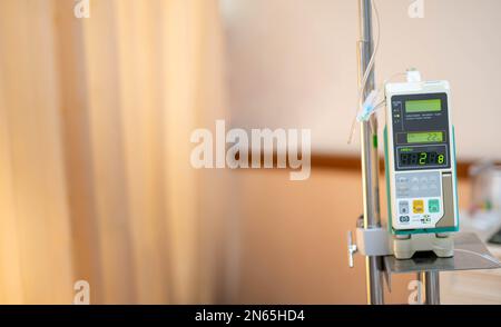 Moderne automatische Infusionspumpe zur Kontrolle infundiert Flüssigkeiten Medikamente oder Nährstoffe Natriumchlorid-Kochsalzlösung Flüssigkeit hängt am Infusionsständer. Stockfoto
