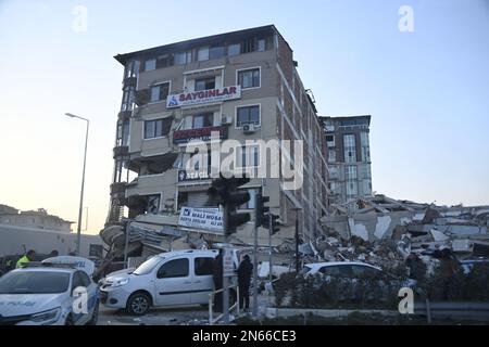 Antakya, Türkei. 09. Februar 2023. Die Leute stehen vor einem zerstörten Haus in Antakya. Mehr als drei Tage nach der Erdbebenkatastrophe ist die Hoffnung auf mehr Überlebende verloren. Unter den Tausenden von eingestürzten Gebäuden im türkisch-syrischen Grenzgebiet gibt es wahrscheinlich immer noch Zehntausende von Erdbebenopfern. Kredit: Anne Pollmann/dpa/Alamy Live News Stockfoto