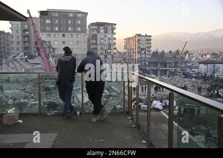 Antakya, Türkei. 09. Februar 2023. Zwei Männer schauen sich zerstörte Häuser im Zentrum von Antakya an. Mehr als drei Tage nach der Erdbebenkatastrophe ist die Hoffnung auf mehr Überlebende verloren. Unter den Tausenden von eingestürzten Gebäuden im türkisch-syrischen Grenzgebiet gibt es wahrscheinlich immer noch Zehntausende von Erdbebenopfern. Kredit: Anne Pollmann/dpa/Alamy Live News Stockfoto
