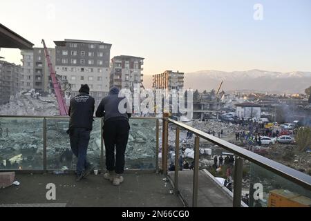 Antakya, Türkei. 09. Februar 2023. Zwei Männer schauen sich zerstörte Häuser im Zentrum von Antakya an. Mehr als drei Tage nach der Erdbebenkatastrophe ist die Hoffnung auf mehr Überlebende verloren. Unter den Tausenden von eingestürzten Gebäuden im türkisch-syrischen Grenzgebiet gibt es wahrscheinlich immer noch Zehntausende von Erdbebenopfern. Kredit: Anne Pollmann/dpa/Alamy Live News Stockfoto