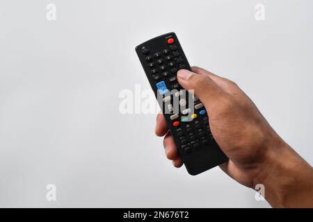 Fernbedienung für Fernseher mit einer Hand isoliert auf weißem Hintergrund Stockfoto