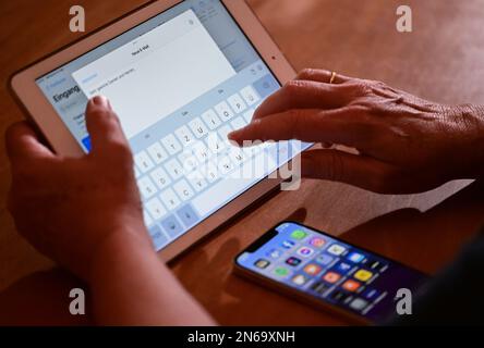 Stuttgart, Deutschland. 09. Februar 2023. ABBILDUNG – Eine Frau tippt eine E-Mail auf einem iPad (Pose Scene). Am 10. Februar kündigt der datenschutzbeauftragte des Landes Baden-Württemberg seinen Tätigkeitsbericht zum Datenschutz 2022 an. Kredit: Bernd Weißbrod/dpa/Alamy Live News Stockfoto