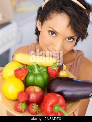 Entdecken Sie das Wunder des Gemüses. Porträt einer jungen Frau, die eine Schüssel voller frischer Produkte hält. Stockfoto