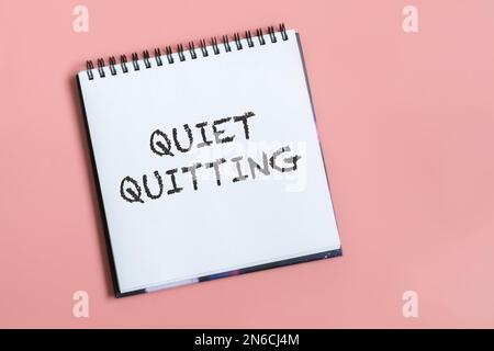 Leiser Text auf Notizbuch auf pastellrosa Hintergrund. Work-Life-Balance, Post-Covid-Philosophie. Draufsicht. Stockfoto