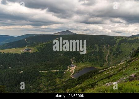 Maly Staw mit Schronisko Samotnia Hütte, Strzecha Akademicka Hütte und Sniezka Hügel im Karkonosze Gebirge in polnisch-tschechischem Grenzland Stockfoto