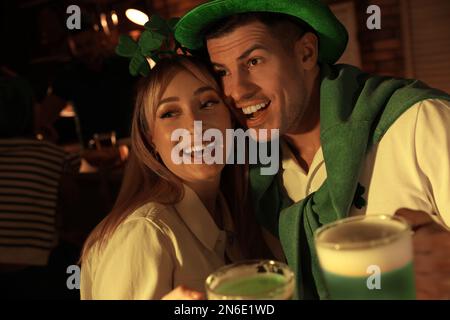 Ein Paar mit Bier, das den St. Patrick's Day in einer Kneipe feiert Stockfoto