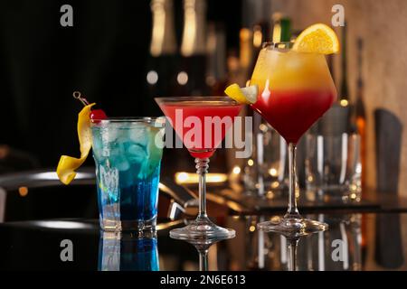 Verschiedene leckere Cocktails auf schwarzem Tisch in der Bar Stockfoto