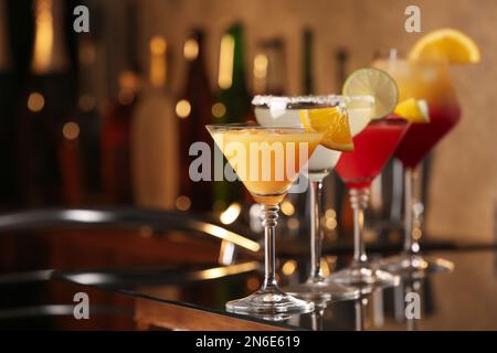 Verschiedene leckere Cocktails auf schwarzem Tisch in der Bar. Platz für Text Stockfoto