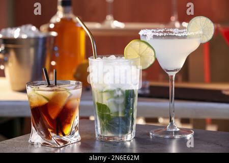 Verschiedene leckere Cocktails auf grauem Tisch in der Bar Stockfoto