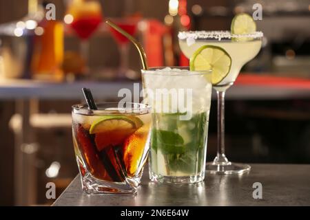 Verschiedene leckere Cocktails auf grauem Tisch in der Bar Stockfoto