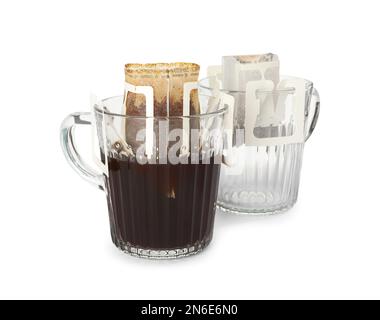 Glasbecher mit Kaffeebeuteln, isoliert auf weiß Stockfoto