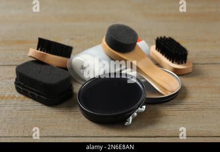 Komposition mit Schuhpflegezubehör auf Holzhintergrund, Nahaufnahme Stockfoto