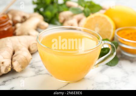 Immunitätsfördernde Getränke und Zutaten auf weißem Marmortisch, Nahaufnahme Stockfoto