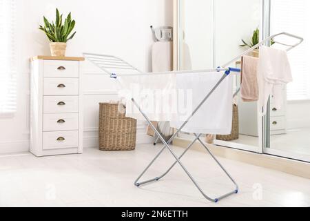 Saubere Wäsche hängt im Innenbereich auf dem Trockengestell Stockfoto