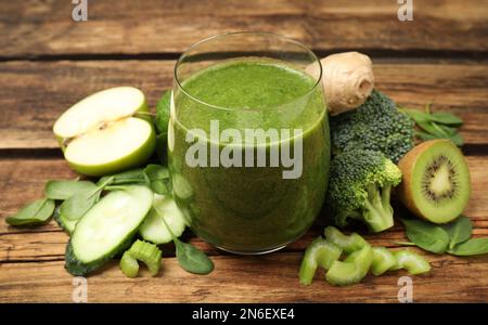 Grüner Saft und frische Zutaten auf Holztisch, Nahaufnahme Stockfoto