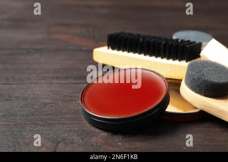Komposition mit Schuhpflegezubehör auf Holzhintergrund, Nahaufnahme Stockfoto