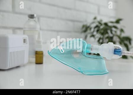 Gesichtsmaske des modernen Verneblers auf dem weißen Tisch. Inhalationsausrüstung Stockfoto