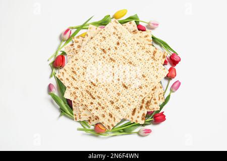 Leckere Matzen und Blumen auf weißem Hintergrund, Draufsicht. Pessach-Feier Stockfoto