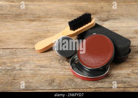 Komposition mit Schuhpflegezubehör auf Holzhintergrund, Nahaufnahme Stockfoto