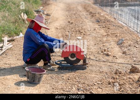 Arbeiter verwenden Fasern, um Stahldrahtwicklungen zu schneiden, um Strukturen zum Gießen von Beton zu bündeln. Stockfoto