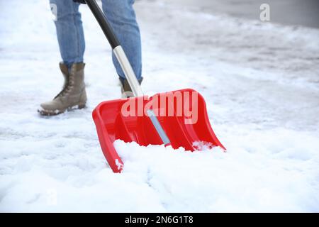 Person schaufelt Schnee im Freien am Wintertag, Schließung Stockfoto