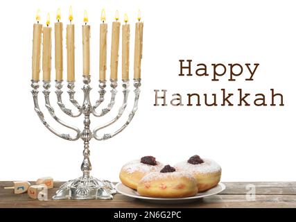 Frohes Chanukka. Silbermenorah, Sufganiyot und Dreidel auf Holztisch Stockfoto