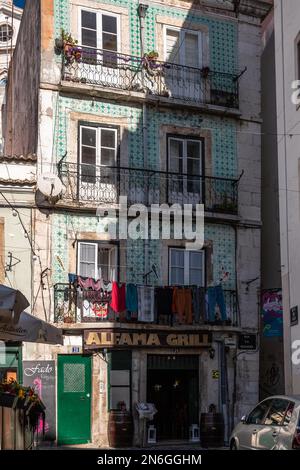 Hausfassaden, enge Gassen, Gassen und Treppen, in einer historischen Altstadt. Wunderschöner urbaner Ort, Alfama am Morgen mit Asulejos - typisch Stockfoto