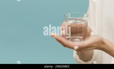 Eine Frau, die Glas mit Wasserkopien in der Hand hält. Auflösung und hochwertige Fotos Stockfoto