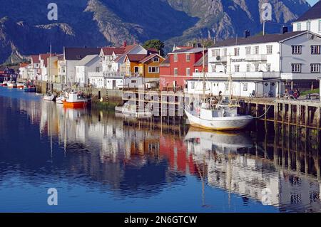 Fischerboote und Fischerhäuser spiegeln sich in den ruhigen Gewässern eines Hafens, Stille, Ruhe, Henningsvaer, Nordland, Lofoten, Norwegen Stockfoto