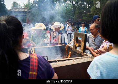 Touristen mit Räucherstäbchen im Llama-Tempel, Peking, China Stockfoto