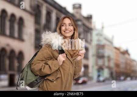 Glücklicher Reisender mit Rucksack in fremder Stadt während des Urlaubs Stockfoto