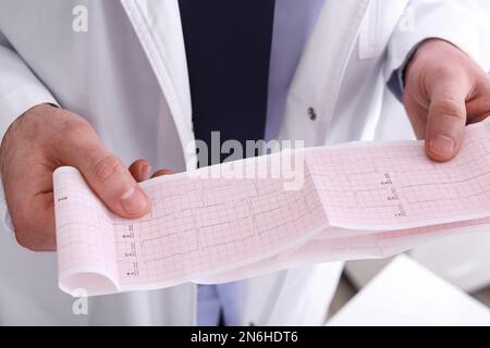 Arzt untersucht Kardiogramm in der Klinik, Nahaufnahme Stockfoto