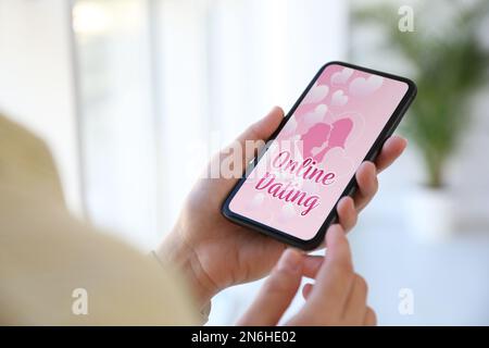 Frau besucht Dating-Seite über Smartphone drinnen, Nahaufnahme Stockfoto